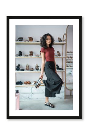 portrait of beautiful asian woman try to put a shoes on while shopping in fashion boutique store. fitting customer