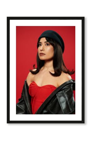 Young asian woman showcases bold fashion statement against vibrant backdrop of red
