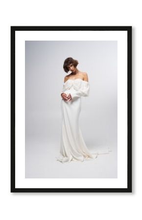 Elegant bridal gown showcased by model in a minimalist studio setup during a fashion shoot highlighting modern bridal styles