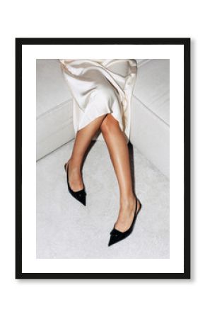 Elegant display of fashion with sleek black shoes and a satin dress