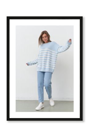 Stylish model showcases playful fashion in soft blue hues during studio shoot