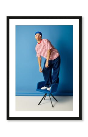 Stylish young man showcases trendy fashion on a vibrant blue background