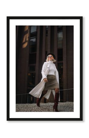 Stylish woman walking confidently in urban setting wearing modern fashion
