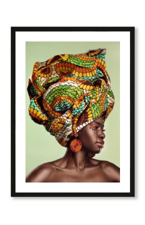 Life is better in colour. Studio shot of a beautiful young woman wearing a traditional African head wrap against a green background.