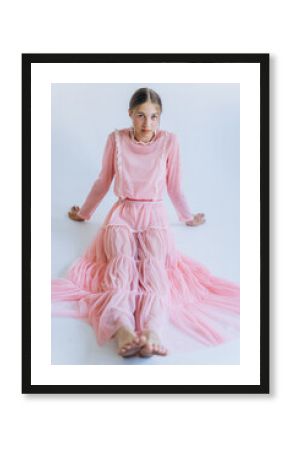 Young beauty joyful blondie girl model in pink fashion dress posing in studio on white background