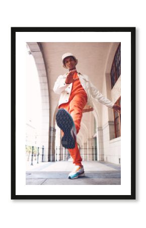 Fashion, model and gen z man from Spain with neon, trendy and luxury brand clothes. Clothing brand and leg kick pose of a hipster Spanish person with sports shoes posing by a building outdoors