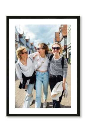 Three cheerful young adult women friend walk street old european german town city street enjoy having fun laughing sunny day together. Female persons friendship celebration party weekend