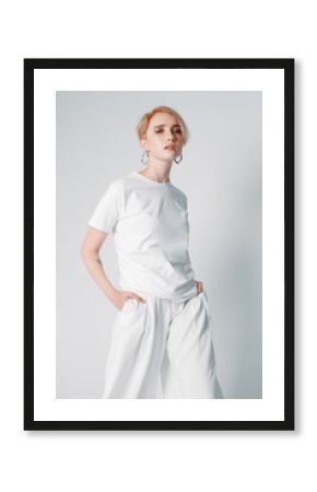 Portraits of a beautiful girl with a short hairstyle on a white background in a white T-shirt