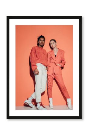 Casual couple in red leaning against a red wall