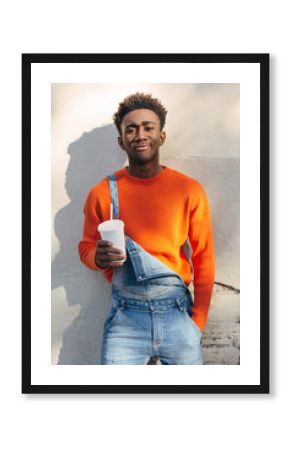 Portrait of a cool black man holding a refreshment outdoors.