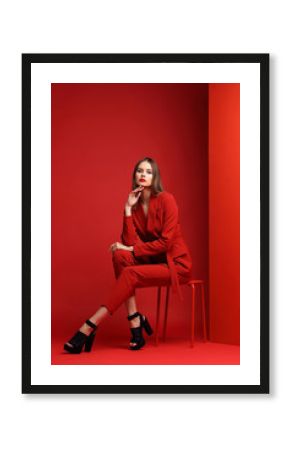 Fashion young woman in red suit.