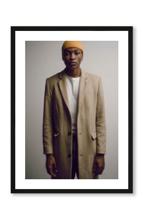 Studio portrait of young man wearing long khaki coat