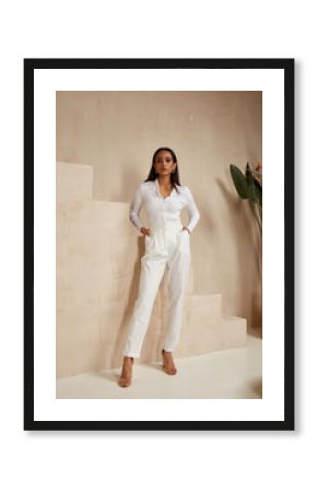 Beautiful sexy brunette woman tanned skin face cosmetic makeup wear white suit pants for date walk office fashion clothes style collection interior room  sand color safari summer casual.