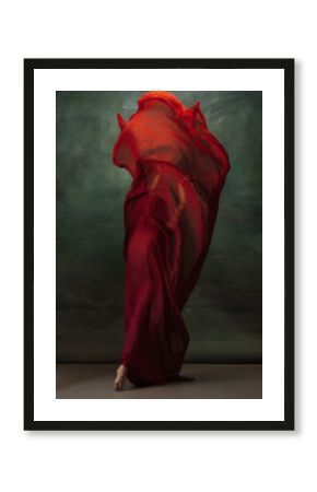 Fire flame. Graceful classic ballerina dancing on dark studio background. Deep red cloth. The grace, artist, movement, action and motion concept. Looks weightless, flexible. Fashion, style.