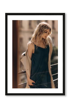 Fashionable portrait of a stylish blonde woman in elegant totall beige look and a combination dress. Spring - autumn fashion concept. Soft selective focus.