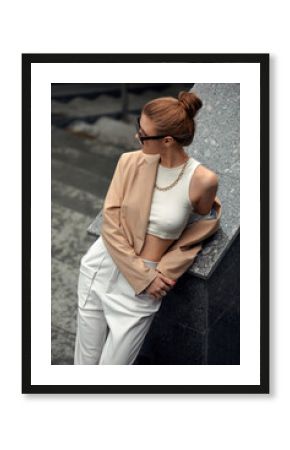 Outdoor close up portrait of young beautiful fashionable girl posing in street. Model wearing stylish sunglasses and light-colored clothing. City lifestyle. Female fashion concept