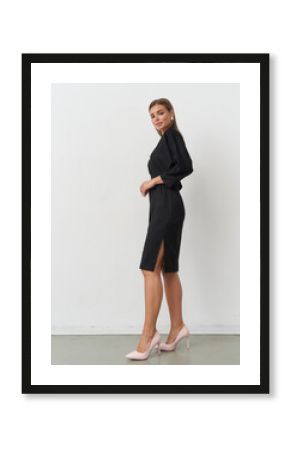 Model showcases elegant black dress in a stylish studio setting for contemporary fashion