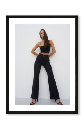 Elegant female model showcasing contemporary fashion in a minimalistic studio