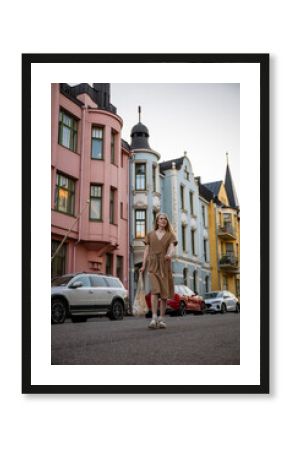 woman walking on Huvilakatu street with colorful buildings in Helsinki