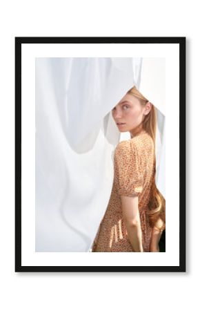 Young Woman in Floral Dress Posing Behind Sheer Fabric