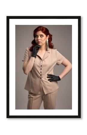 Confident woman with red hair, black gloves, beige outfit, thoughtful expression, modern earrings, fashion style concept