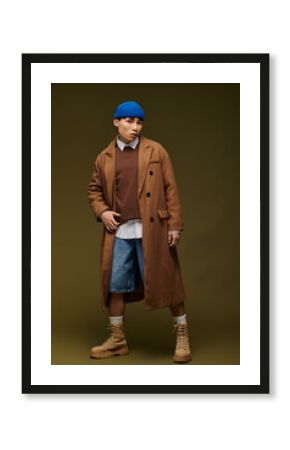 Stylish young Asian man exudes confidence in trendy attire against a minimalist backdrop