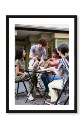 Waiter pouring coffee for customers in street cafe