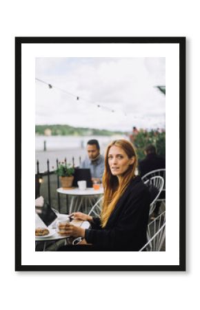 Portrait of female freelancer sitting with laptop at cafe