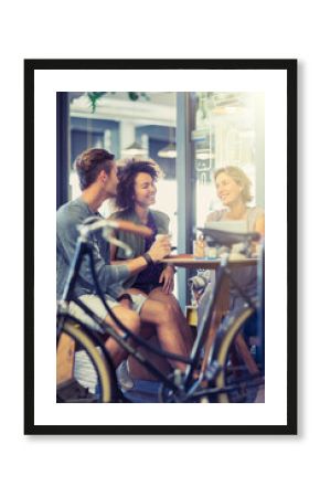 Friends hanging out at cafe table behind bicycle