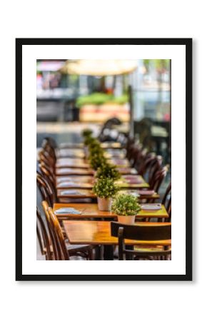 A row of chairs and tables at a outdoor cafe on Lygon Street, Carlton, Melbourne, Australia