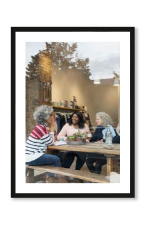 Women friends drinking tea in cafe shop window