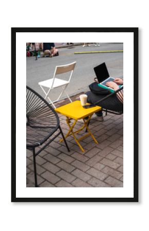 Anonymous street moment sitting with cafe and laptop