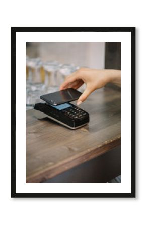 Customer paying cashless with smartphone in a cafe