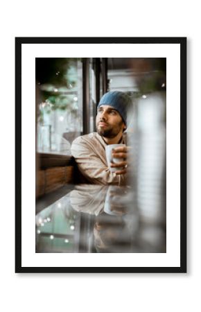 Handsome man with coffee cup day dreaming in cafe