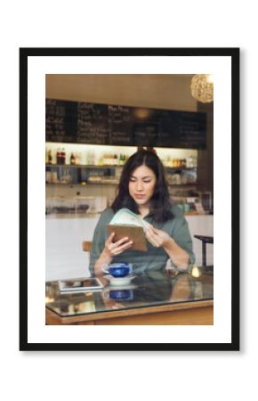 Woman looking at menu in cafe
