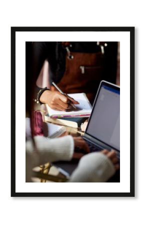Close up of a multicultural student's hand writes tasks in a textbook.
