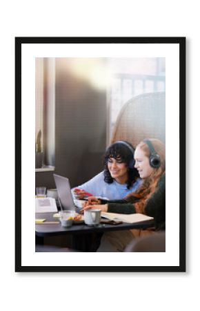 Female friends using laptop in cafe