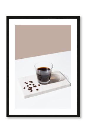 Vaso de café negro sobre mármol y fondo beige