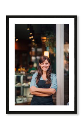 Portrait of a cafe owner standing in the doorway, smiling at camera.