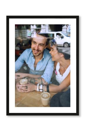 Smiling man and woman speaking in cafe
