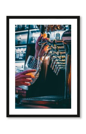 bartender hand at beer tap pouring a draught beer in glass serving in a restaurant or pub