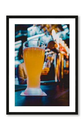 glass of light beer stands on a table in a bar or pub