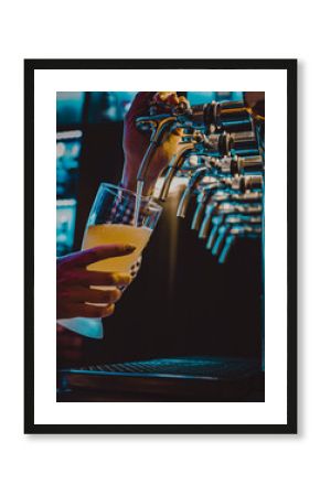 bartender hand at beer tap pouring a draught beer in glass serving in a restaurant or pub