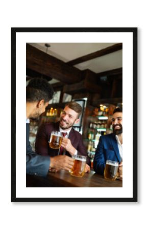 People, friendship and celebration concept. Happy business male friends drinking beer at pub