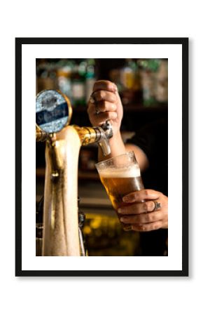 Person pouring a beer in a pub
