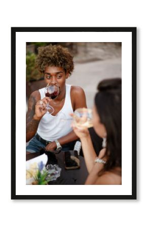 An afro-haired man at the bar with a female friend