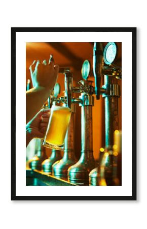 Male hands, bartender pouring delicious crafted beer from taps in glass. Warm atmosphere of bar, pub. Refreshment and relaxation. Concept of beer drink, alcohol, brewery, pub atmosphere, taste