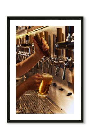 Female bartender pouring lager foamy beer from tap into mug. Modern beer bar, restaurant. Concept of beer, brewery, pub, Oktoberfest, traditions