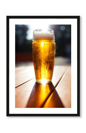 Glass of light beer, Background - blurred sunny forest.