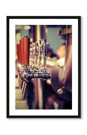 many metal taps with the wooden handle for draft beer